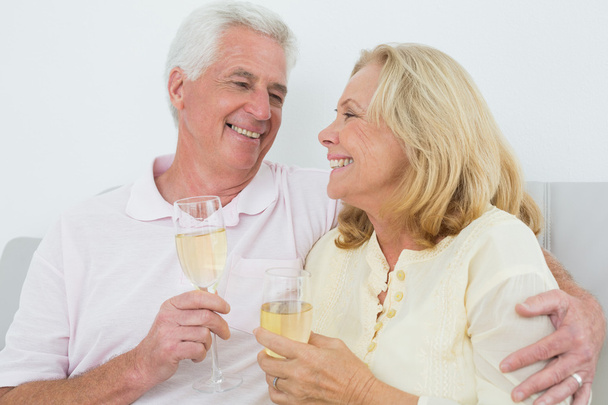Senior couple with champagne flutes at home - Foto, imagen