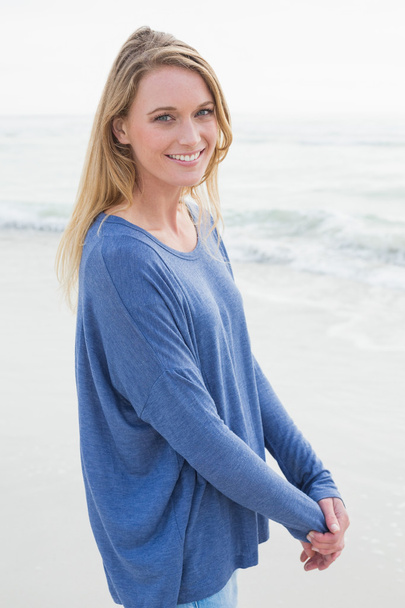 Portrait of a smiling casual woman at beach - Photo, Image