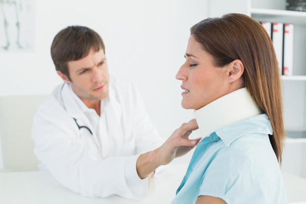 Doctor examining a patient's neck in medical office - Photo, image
