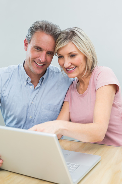 Casual couple using laptop at home - Fotó, kép