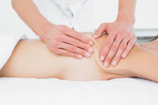 Mid section of a physiotherapist massaging woman's body - Foto, imagen