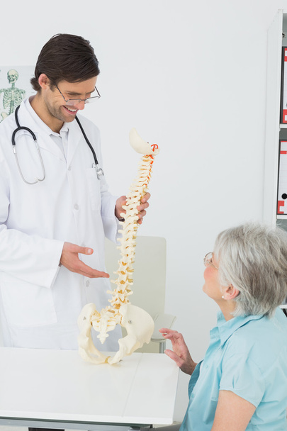 Male doctor explaining the spine to a senior patient - Foto, Bild