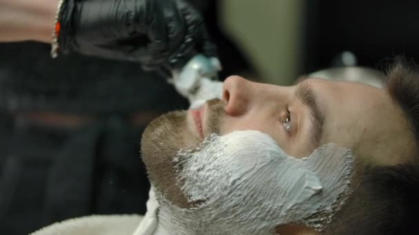 Περικοπή θηλυκό κουρέα εφαρμογή αφρού στο μάγουλο του πελάτη - Πλάνα, βίντεο