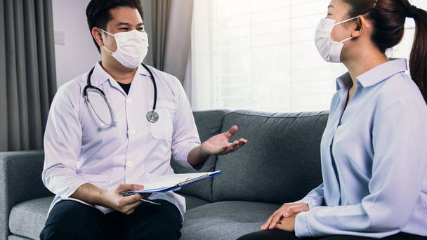 De arts bezocht de patiënt terwijl hij thuis een masker droeg om de behandeling van de patiënt tijdens de virusepidemie te controleren.. - Foto, afbeelding