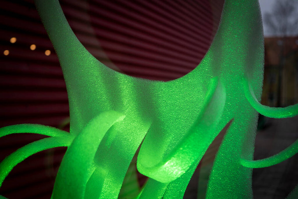 Κοντινό πλάνο πράσινων αφηρημένων λωρίδων αφρώδους υλικού σε σκούρο φόντο - Φωτογραφία, εικόνα