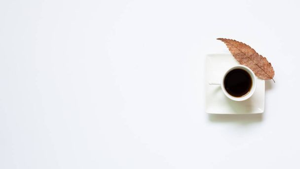 Coupe de café avec des feuilles sur fond blanc. vue de dessus - Photo, image
