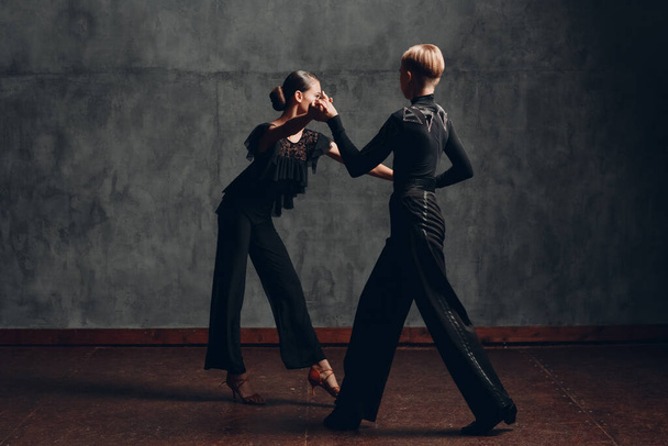 Пара в чорних костюмах танцює в бальних танцях ромба
 - Фото, зображення