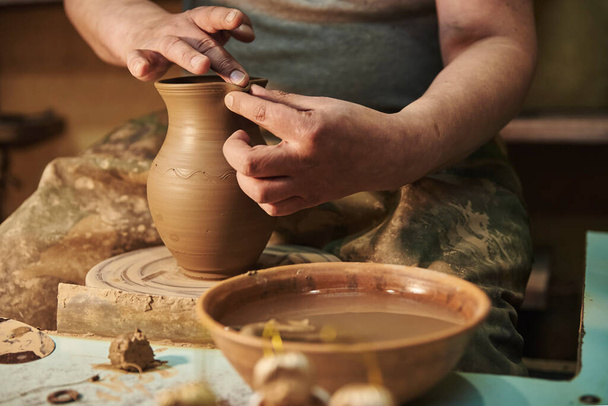 El proceso de la fabricación de la vasija de barro a la rueda del alfarero en el taller. Potter en el trabajo
 - Foto, Imagen