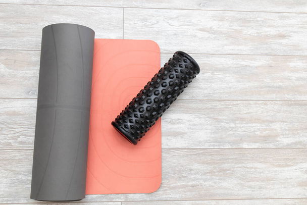 Rouleau de mousse et tapis de yoga dans le salon pour le yoga de méditation. Vue du dessus. - Photo, image
