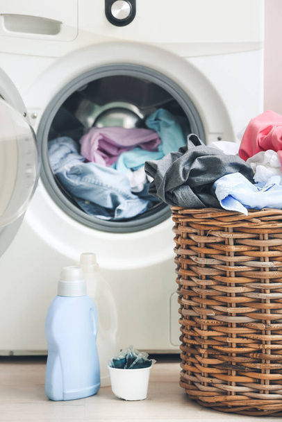Washing machine and basket with dirty clothes in home laundry room - Photo, Image
