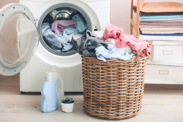 Washing machine and basket with dirty clothes in home laundry room - Foto, Imagem