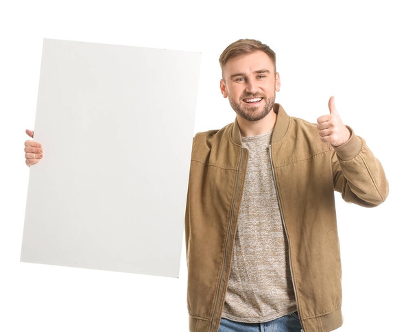 Fiatal férfi üres táblával mutatja hüvelykujj-up fehér háttér - Fotó, kép