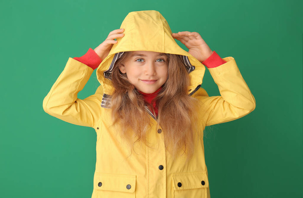 Roztomilé holčička v pláštěnce na barevném pozadí - Fotografie, Obrázek