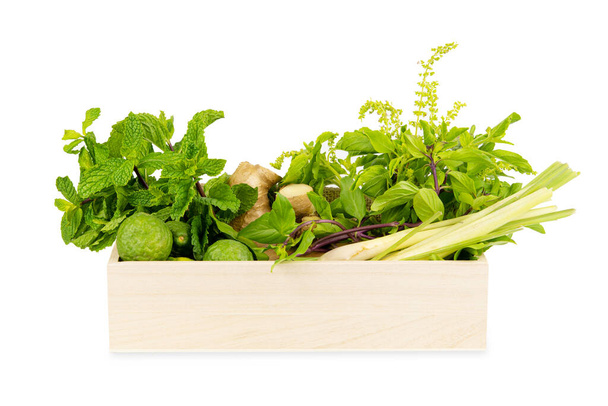 Divers ingrédients d'herbes asiatiques fraîches nourriture dans une boîte en bois isolée sur fond blanc - Photo, image