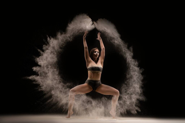 Slim female dancer throwing dust in air - Fotó, kép