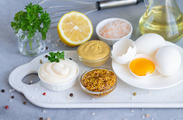 Sosy organiczne domowej roboty: majonez, musztarda i sos musztardowy dijon ze składnikami do ich gotowania - Zdjęcie, obraz