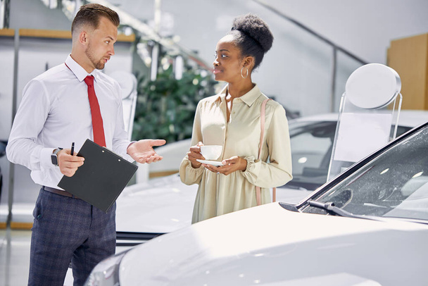 caucasian car dealer explaining sales contract to customer - Zdjęcie, obraz