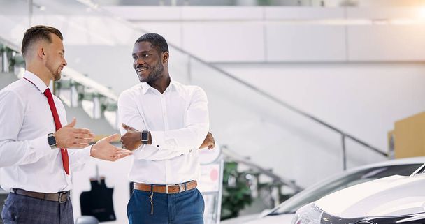 african businessman ask questions about car presented in dealership - 写真・画像