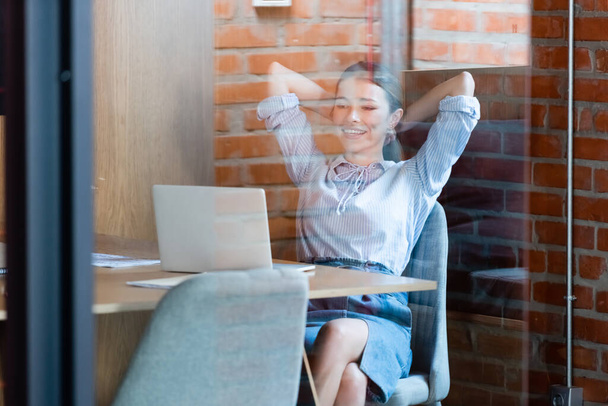 selective focus of happy businesswoman looking at laptop - Photo, Image