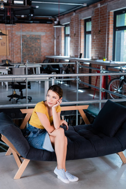 attractive businesswoman sitting on sofa in modern office - Photo, Image