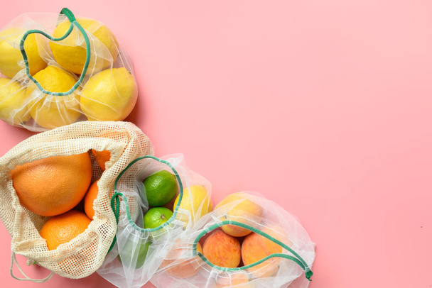 Citrics, lime, lemon, orange in reusable eco friendly mesh bags on pink background. Zero waste shopping. Ecological concept. Stop pollution. Copy space. - Fotoğraf, Görsel