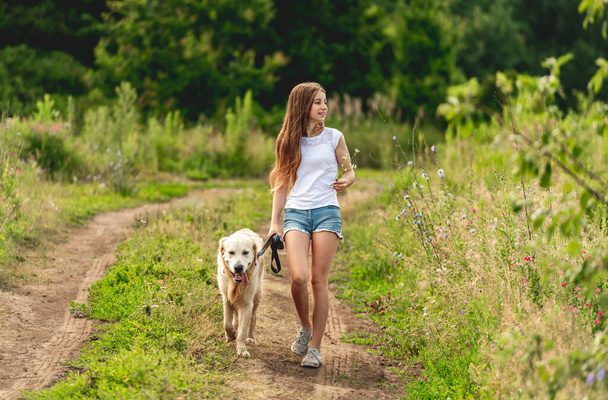 Girl running with dog on nature - Valokuva, kuva