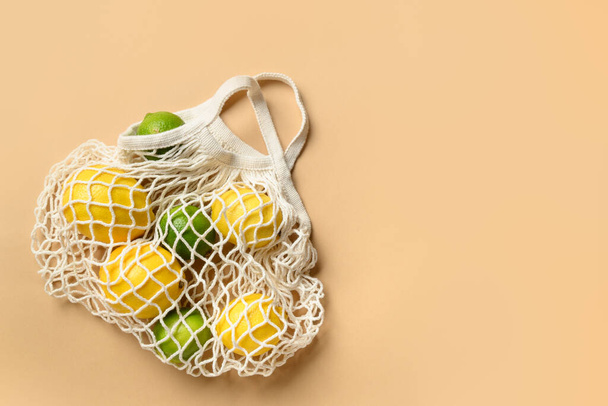 Shopping eco mesh bag with friuts, lemon, lime, banana on beige. Zero waste. View from above. - Fotó, kép