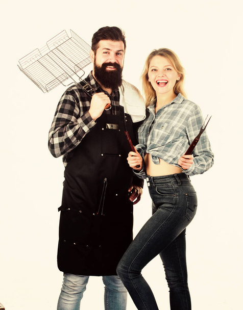 Man bearded hipster and girl ready for barbecue party. Culinary concept. Family weekend. Couple in love hold cooking utensils for barbecue. Tools for roasting meat outdoors. Picnic and barbecue - Foto, immagini