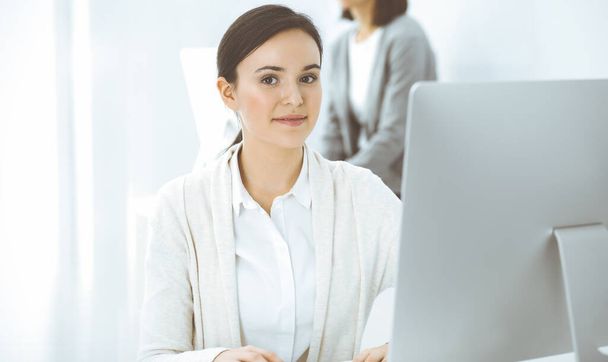 Casual dressed business woman working with computer in office. Lawyer or accountant at work - Photo, image