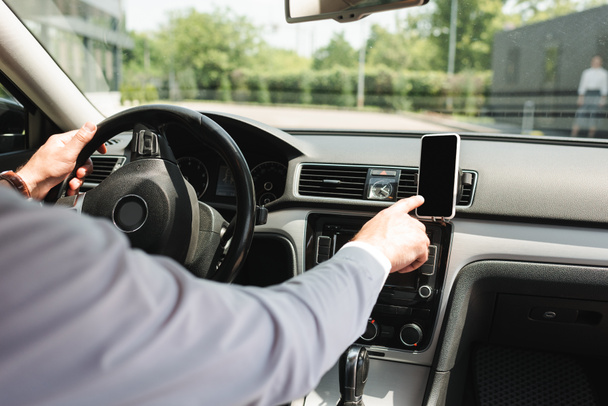 Cropped view of businessman using smartphone while driving auto   - Photo, Image