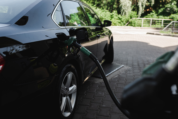 Az üzemanyagtöltő fúvóka szelektív fókusza nyitott benzintartályban auto benzinkúton  - Fotó, kép