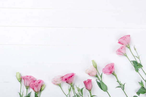 Čerstvé růžové eustoma květiny na bílém dřevěném pozadí - Fotografie, Obrázek