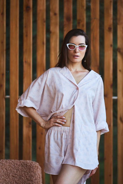 Woman in pajamas over wooden background on terrace. Good morning concept. - Foto, immagini