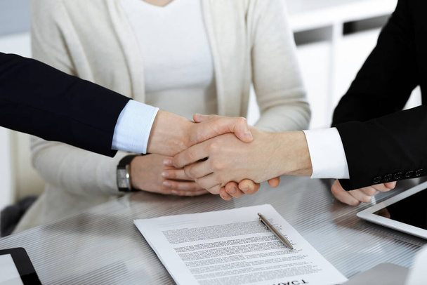 Business people shaking hands after contract signing in modern office. Teamwork, partnership and handshake concept - 写真・画像