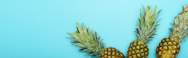 shora pohled na zralé ananas na modrém pozadí, panoramatický snímek - Fotografie, Obrázek