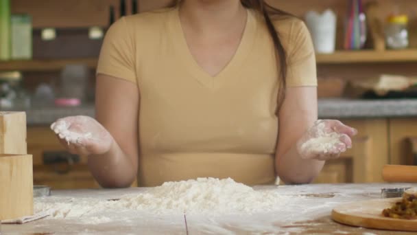 Frauenhände in Großaufnahme bereiten sich auf das Kneten von Teig auf dem Tisch vor, der mit Mehl pulverisiert wird - Filmmaterial, Video