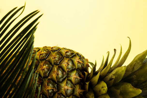 köstliche süße Ananas und Palmblatt isoliert auf gelb - Foto, Bild