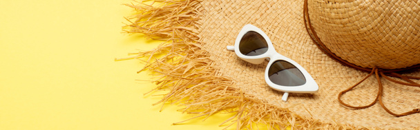strohoed en stijlvolle suikerbril op gele achtergrond, panoramisch shot - Foto, afbeelding
