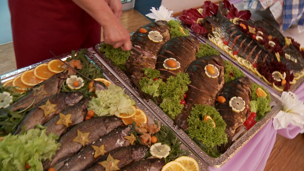 Frau schneidet Fisch im Buffet - Filmmaterial, Video