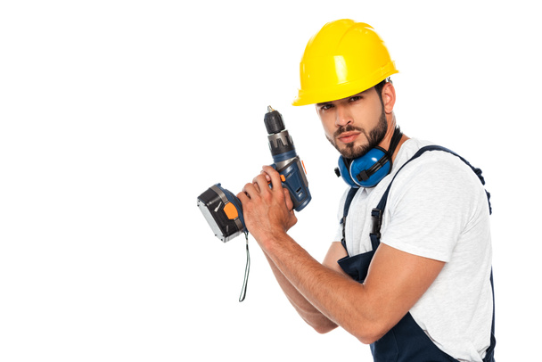 Handsome workman in hardhat and ear defenders holding electric screwdriver isolated on white - Photo, Image