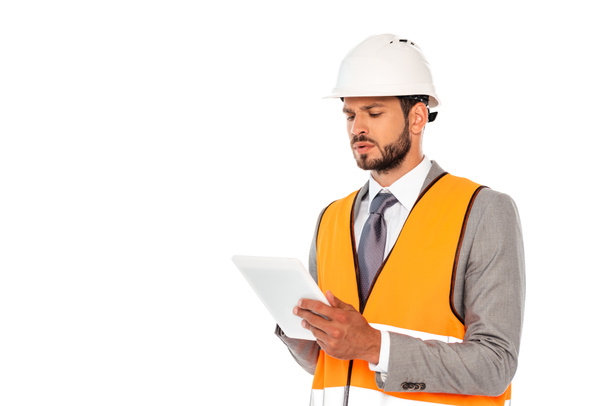 Handsome engineer in suit and safety vest using digital tablet isolated on white - Фото, изображение