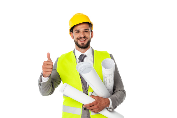 Ingeniero guapo mostrando el pulgar hacia arriba mientras sostiene planos y sonríe a la cámara aislada en blanco
 - Foto, Imagen