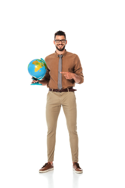Handsome teacher pointing with finger at globe and smiling at camera on white background - Fotoğraf, Görsel