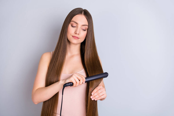Close-up portrait of her she nice-looking attractive charming shine well-groomed brown-haired girl straightening smoothing hair isolated over light gray pastel color background - Fotografie, Obrázek