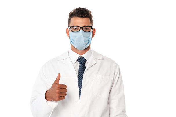 Врач в медицинской маске и белом халате показывает одобренный жест, изолированный на белом
 - Фото, изображение