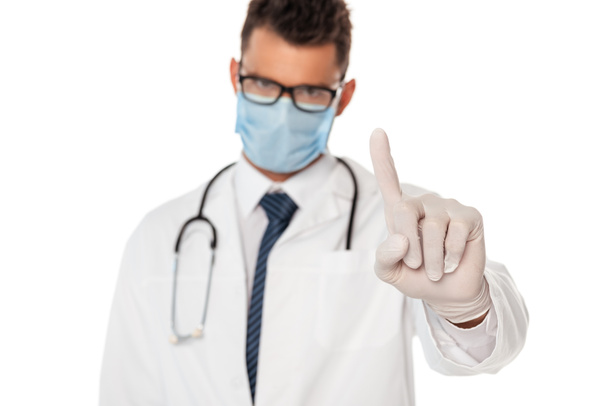 Enfoque selectivo del médico en máscara protectora y gafas apuntando con el dedo aislado en blanco
 - Foto, Imagen