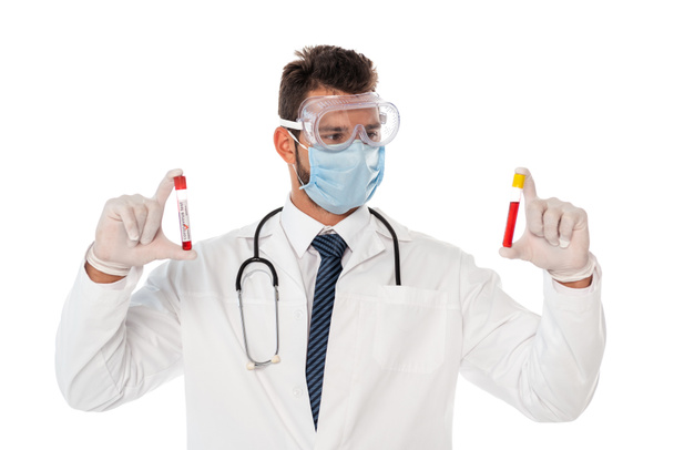 Arzt mit Schutzmaske und Schutzbrille hält Reagenzgläser mit Blutproben auf weiß isoliert - Foto, Bild