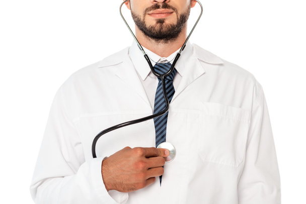Cropped view of doctor holding stethoscope near chest isolated on white - Foto, afbeelding
