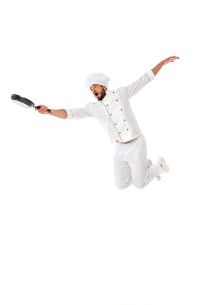 Chef excitado sosteniendo sartén mientras salta aislado en blanco
 - Foto, imagen
