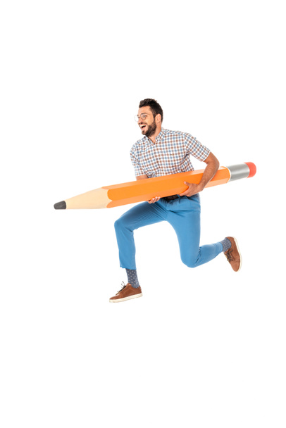Smiling nerd holding huge pencil while jumping isolated on white - Foto, Bild